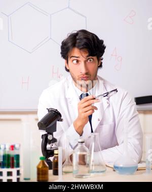 Young funny chemist in front of white board Stock Photo