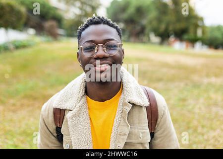 Smiling african young student man looking at camera outdoors Stock Photo