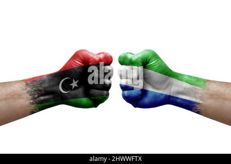 Two hands punch to each others on white background. Country flags painted fists, conflict crisis concept between libya and sierra leone Stock Photo