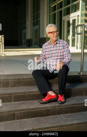 Senior businessman holding a tablet and smiling Stock Photo