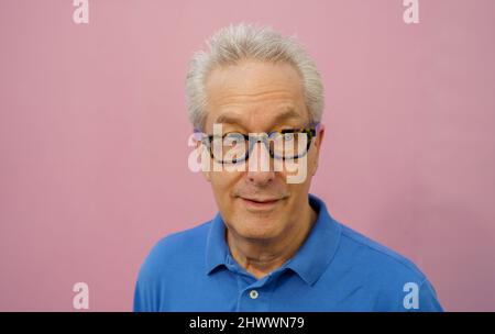 Handsome businessman in blue shirt on pink background Stock Photo