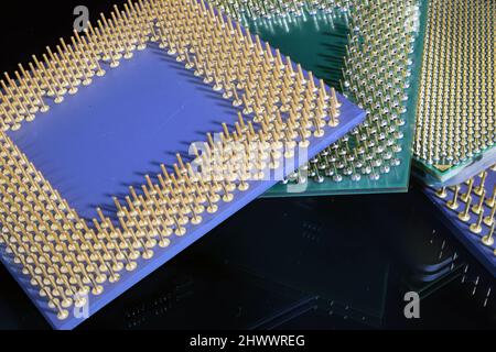 Multiple Generations of Computer CPU's in a close up showing the golden  pins Stock Photo