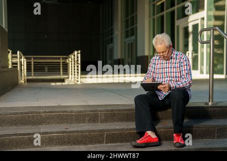 Cool senior businessman working on a tablet Stock Photo