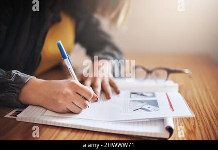 Her study methods are take notes. Cropped shot of an unrecognizable female university student in class. Stock Photo