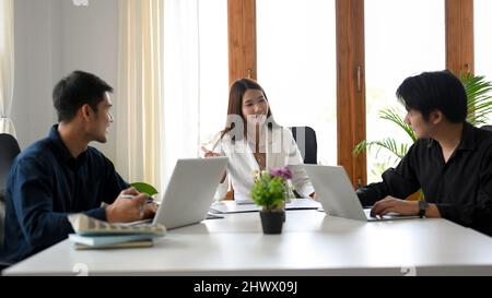 A group of successful business entrepreneurs is having a business cooperating meeting in the office. Stock Photo