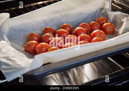 Cherry tomatoes are ready after baking in the oven for appetizer with ricotta cheese and cherry tomatoes. Stock Photo