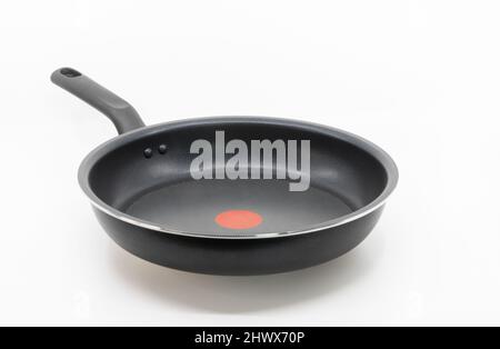 Black non-stick skillet with the handle on white background, empty space on the pan, view from the front. Stock Photo