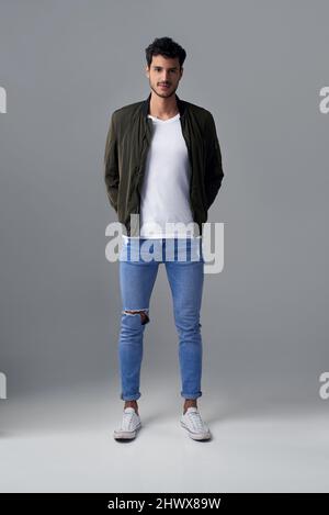 Confidence sure looks good on him. Studio shot of a handsome young man posing against a grey background. Stock Photo