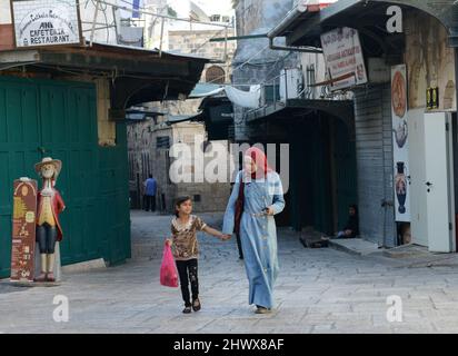 A Palestinian woman with holding her little girl in the Muslim Quarter in the old city of Jerusalem. Stock Photo