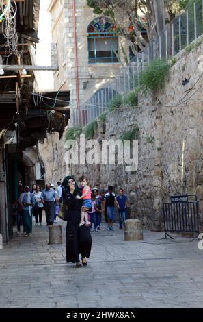 A Palestinian woman with holding her little girl in the Muslim Quarter in the old city of Jerusalem. Stock Photo