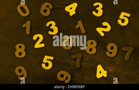 Many golden and yellow numbers on blackboard top view Stock Photo