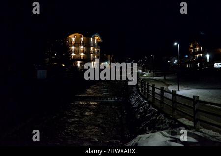 Photos of the snowcapped Dolomites during a winter trip, the small villages in the mountain valleys and the ski slopes at night Stock Photo