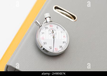 Grey and yellow office folder on the chronometer. Stock Photo