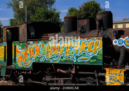 ‘Help’, 'Hilfe' and 'Pomoc', plea for help in three languages, English, German and Czech.  Graffiti on a rusty steam loco at the north east terminus of the Waldviertelbahn 760mm narrow gauge heritage railway network at Heidenreichstein, Gmund, Lower Austria. Stock Photo