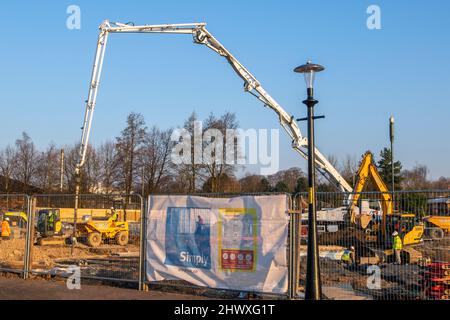 Groundwork contractors in Preston, Lancashire.  UK Weather March 2022. In temperatures of 2.5 degrees Celsius, foundation work on the Morar Car Home site begins. Temperatures are set to climb when Technic Concrete Pumping, a £500,000 hydraulic machine, transports wet concrete from 15 concrete mixers expected to arrive at the Preston Docks site on Navigation Way. The already-piled site will now get 175 cubic metres of cement as the foundation for the two-story structure. Credit; MediaWorldImages/AlamyLiveNews Stock Photo