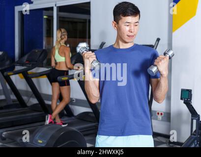 Man doing exercises with dumbbells Stock Photo