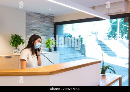 Receptionist speaking on phone at physiotherapy centre Stock Photo