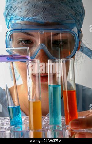 A Young Lab Technician with a number of Substances in test tubes ...