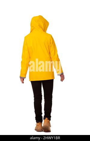 Rear view of a woman wearing a yellow coat with hood up, cut out, Stock Photo