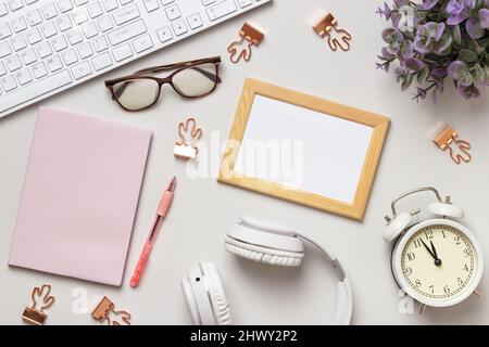 Desktop. Frame notepad keyboard alarm clock glasses headphones on the table. Stock Photo