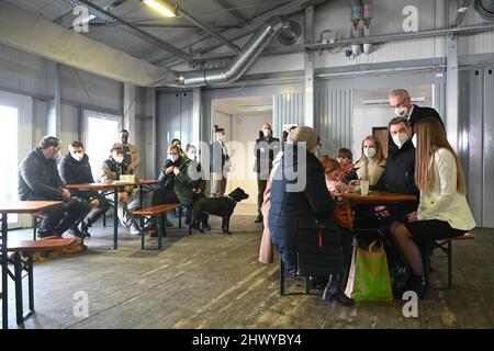 Munich, Germany. 08th Mar, 2022. Markus Söder (CSU, 2nd from right), Minister-President of Bavaria, and Joachim Herrmann (CSU, 3rd from right), Minister of the Interior of Bavaria, talk to a refugee family from Kramatorsk in Ukraine. Credit: Tobias Hase/dpa/Alamy Live News Stock Photo