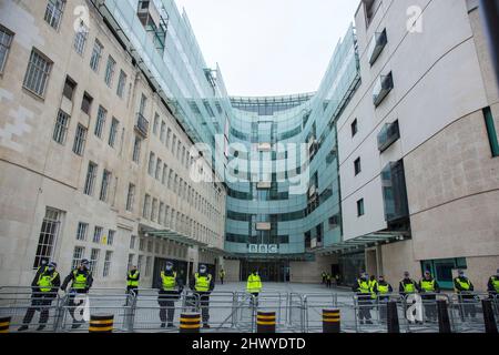 Police officers stand guard as participants gather for a World Wide Rally for Freedom in front of the BBC Broadcasting House in London.
