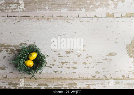 glass eggs in a nest on a wooden background Stock Photo