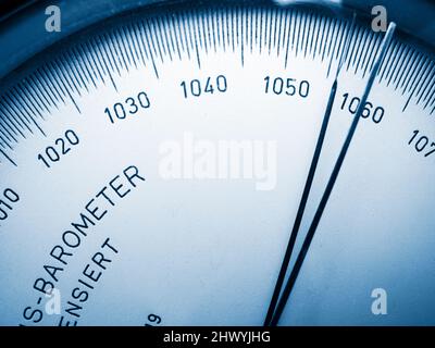 Close-up view of the scale with pointer of an analogue barometer blue toned. Stock Photo