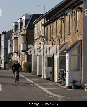 Man Cycling By Cottages Market Street Old Harlow Essex Stock Photo