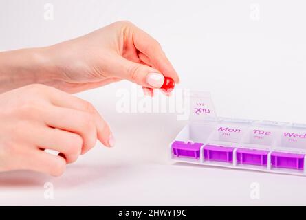 Woman hands taking pill or vitamin from organizer. Daily health treatment and medication concept. High quality photo Stock Photo