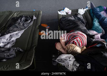 Krakow, Poland. 08th Mar, 2022. A women seen lying on the camp-bed in the sports hall of the Cracovia club where accommodation was organised for refugees from Ukraine coming to Krakow. Credit: SOPA Images Limited/Alamy Live News Stock Photo