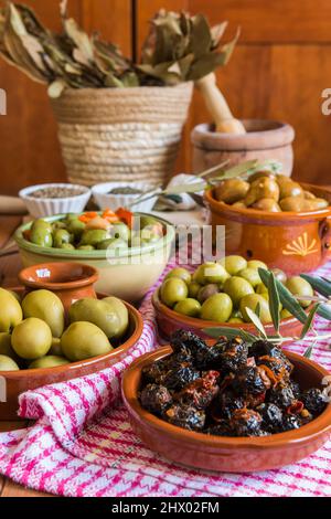 Still life with different varieties of olives, presented in bowls, dressed with different traditional dressings. Traditional homemade dressings, typic Stock Photo