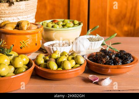 Still life with different varieties of olives, presented in bowls, dressed with different traditional dressings. Traditional homemade dressings, typic Stock Photo