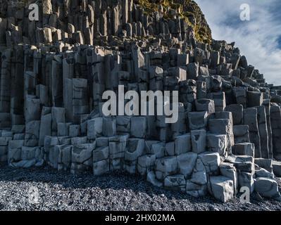 Basalt rock pillars columns at Reynisfjara beach near Vik, South Iceland. Unique geological volcanic formations. Natural stone texture background. Stock Photo