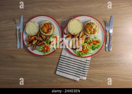 Home made cheese burgers with potatoes wedges and side salad Stock Photo