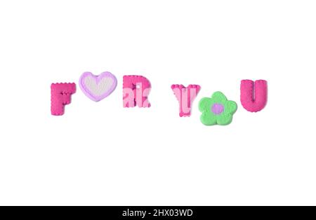 Text of FOR YOU spelled with french rose pink alphabet shaped cookies and marshmallow on white backdrop Stock Photo