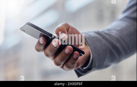 Working on the go. Shot of a businessperson using a smartphone. Stock Photo