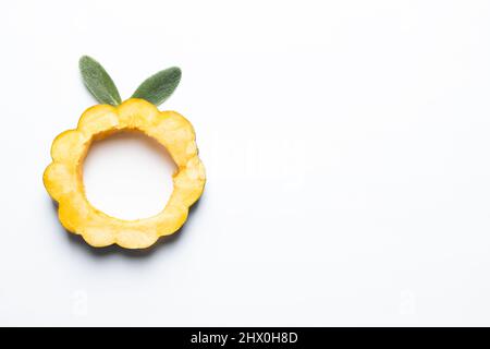 Sliced acorn squash with lambs ear leaves isolated on a white background. Stock Photo