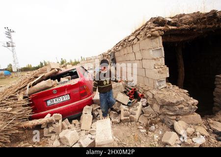 VAN, TURKEY - OCTOBER 25: Earthquake victim child in front of the their destroyed houses in the Van-Ercis Earthquake on October 25, 2011 in Van, Turkey. Stock Photo