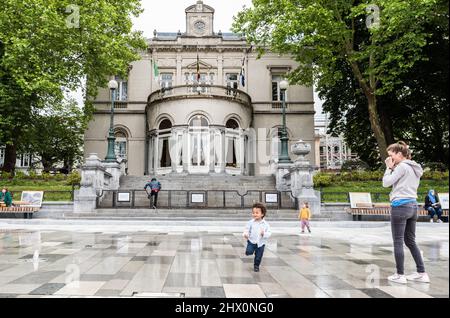 Ixelles, Brussels - Belgium - 05 31 2019 - Young boy and mother playing at the fountain in front of the city hall at the Fernand Cocq square Stock Photo