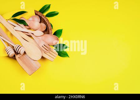 Recycling conceptDisposable cutlery on a pressed paper plate on a yellow background.Eco-friendly disposable utensils made of bamboo wood and paper Stock Photo
