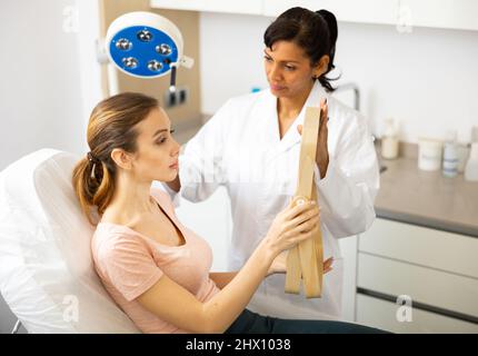 Beautician examining face skin of female patient Stock Photo