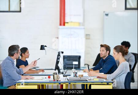 The best minds are on the job. Shot of a group of designers working at their computers in an office. Stock Photo