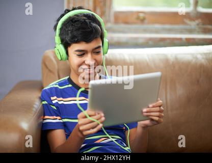 Keeping himself entertained. Cropped shot of a little boy watching a video on his tablet. Stock Photo