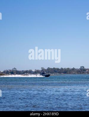 A United States Coast Guard vessel acting as a simulated enemy vessel during Littoral Exercise II (LEX II) drives past Marine Corps Auxiliary Landing Field Bogue, North Carolina, March 2, 2022. During LEX II, Marines and Sailors aim to practice their ability to discourage a notional adversary’s coercive behavior and contribute directly through deterrence with advanced technology systems. The division tested new tactics and training with multi-domain reconnaissance and counter-reconnaissance teams in accordance with Force Design 2030. (U.S. Marine Corps photo by Lance Cpl. Ryan Ramsammy) Stock Photo