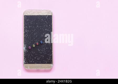 Broken cracks cell mobile phone and text oops on pink background Concept Copy Space Flat Lay Stock Photo