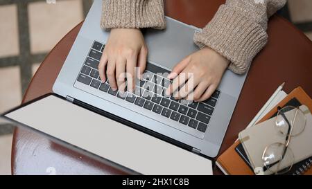 Overhead shot, Female freelancer remote working at outdoor cafe, hands woking on laptop computer. Stock Photo