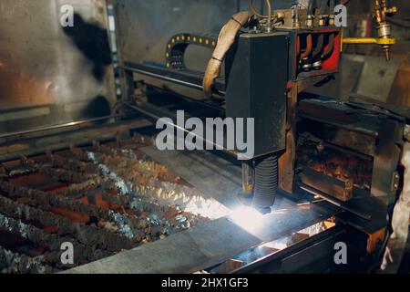 Automatic cnc laser cutting machine working with sheet metal with sparks. Metalworking industrial manufacturing factory. Stock Photo