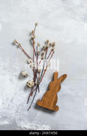 Happy Easter concept with rabbit, willow branches and quail eggs on a gray background. Easter background. Stock Photo