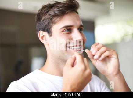 He knows the importance of dental hygiene. Closeup of a young man flossing. Stock Photo